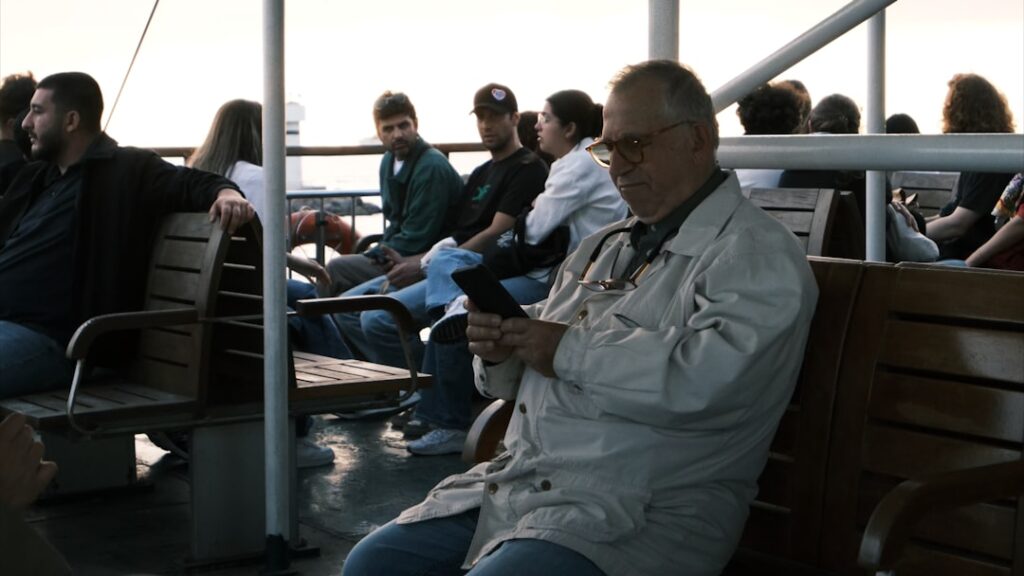 Pessoas Sentadas Em Um Conves De Balsa Olhando Para Telefones BxMyHXu305k