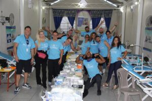 Um Grupo De Pessoas Em Camisas Azuis Posando Para Uma Foto DWg0RAgQeuA