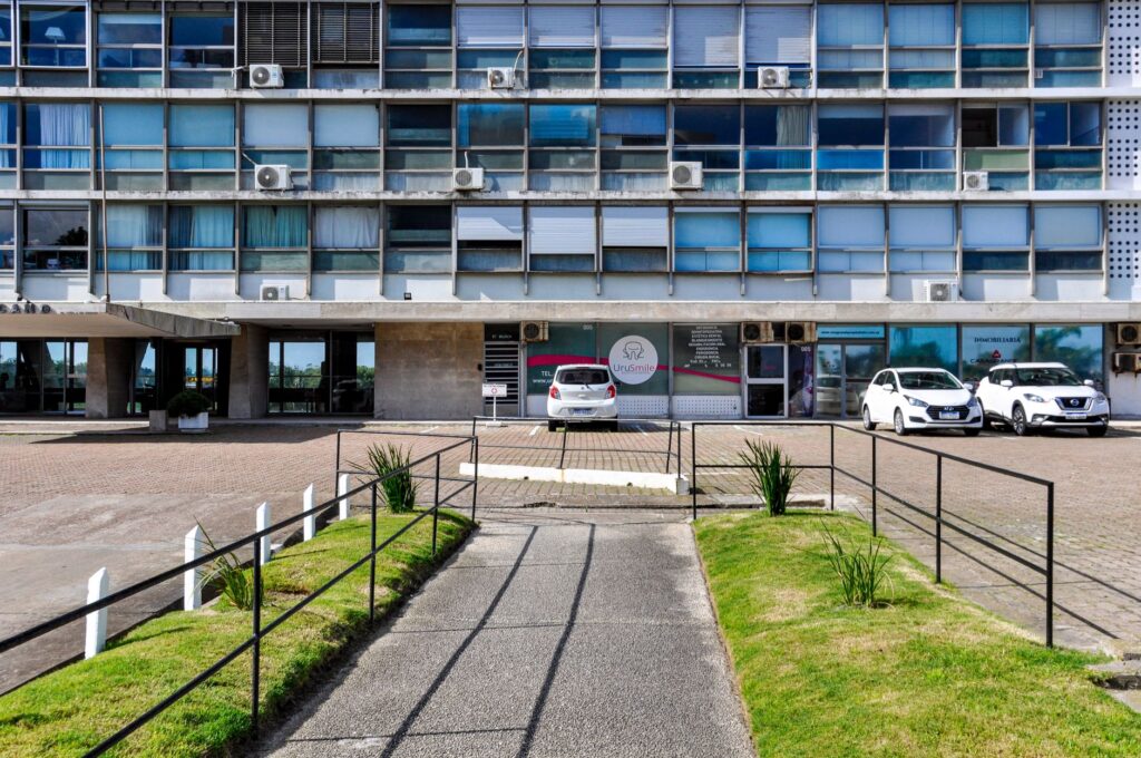 Street view of a modern office building in Montevideo, Uruguay with parked cars.