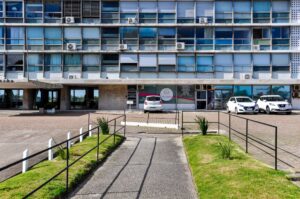 Street view of a modern office building in Montevideo, Uruguay with parked cars.