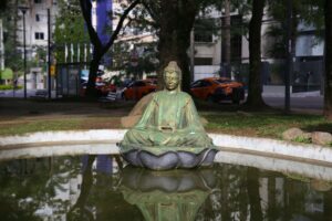 Buddha statue surrounded by a serene park setting in Curitiba, Brazil.