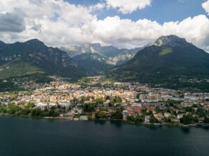 A stunning aerial shot showcasing the breathtaking landscape of an Italian lakeside town surrounded by mountains.