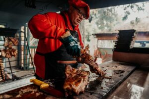 A chef prepares traditional Argentine asado on a grill, highlighting Argentine culinary culture.