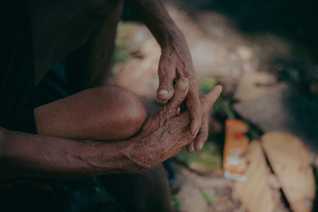 A detailed close-up of weathered hands in a serene outdoor environment, embodying wisdom and history.
