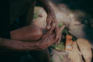 A detailed close-up of weathered hands in a serene outdoor environment, embodying wisdom and history.