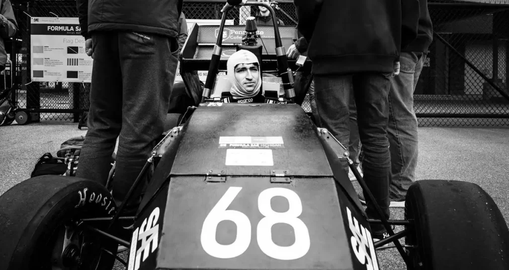 A driver prepares in a race car during an outdoor event in Dearborn, MI.