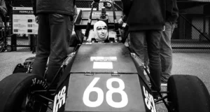 A driver prepares in a race car during an outdoor event in Dearborn, MI.