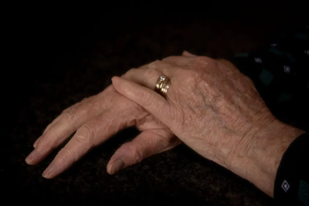 Detailed close-up of elderly hands with gold rings, showcasing age and wisdom.