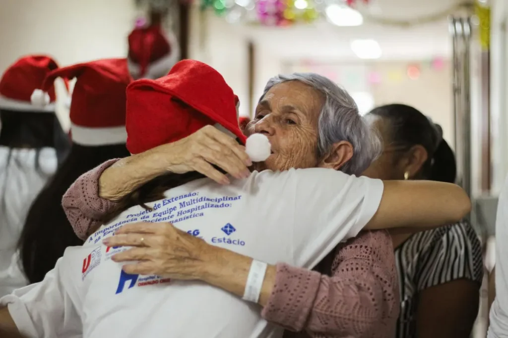 Elderly woman hugging in hospital during festive celebration, fostering connection and joy.